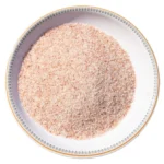 Fine grain Himalayan pink salt crystals neatly displayed in a round white decorative ceramic plate
