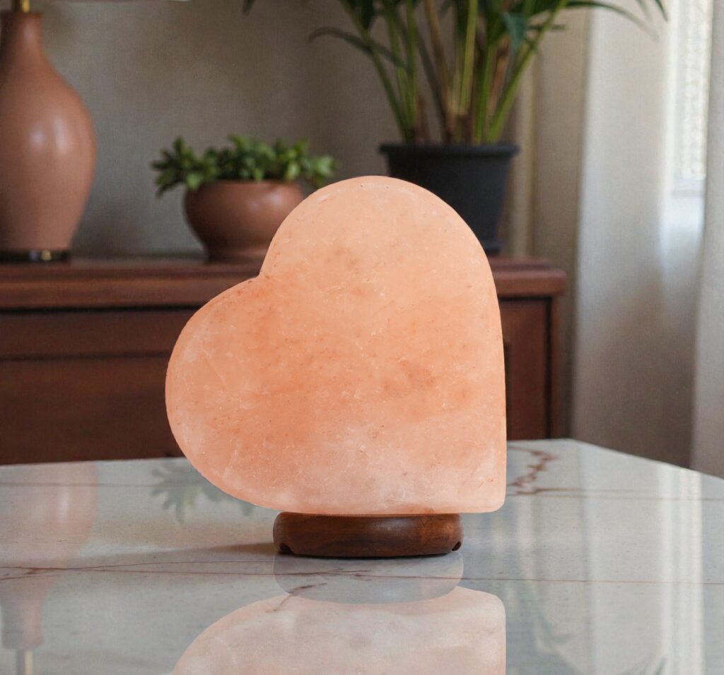 Handcrafted heart shape USB table lamp pink salt with smooth curved contours mounted on a dark circular wooden base