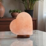 Handcrafted heart shape USB table lamp pink salt with smooth curved contours mounted on a dark circular wooden base