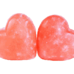 Two handcrafted heart-shaped Himalayan Pink Salt Massage Stones carved from pure natural rock salt crystal