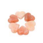 Six handcrafted heart-shaped Himalayan Pink Salt Massage Stones arranged in a circular formation carved from pure natural rock salt crystal
