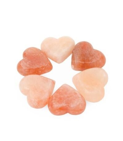Six handcrafted heart-shaped Himalayan Pink Salt Massage Stones arranged in a circular formation carved from pure natural rock salt crystal