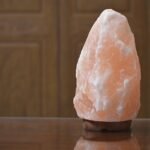 Natural shape USB lamp pink salt with rugged crystalline facets mounted on a round dark wooden base