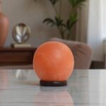 Handcrafted illuminated round shape USB lamp salt carved from Himalayan pink salt mounted on a dark circular wooden base