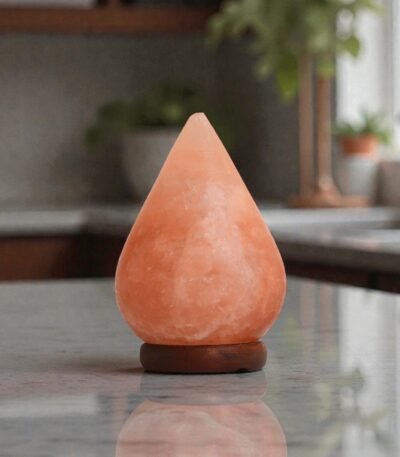 Handcrafted illuminated tear drop table lamp carved from Himalayan pink salt mounted on a circular dark wooden base
