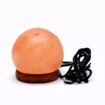 Handcrafted round USB globe shaped Himalayan pink salt lamp with wooden base and attached black USB power cable.