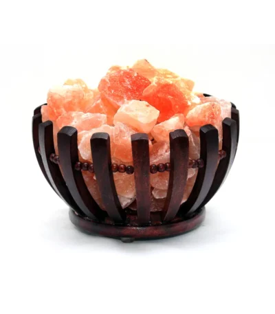Handcrafted flared dark wooden bowl with beaded trim filled with raw Himalayan pink salt crystal chunks.