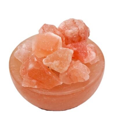Handcrafted pink salt bowl with natural shape salt chunks and dark polished wooden base filled with rough rock salt crystals