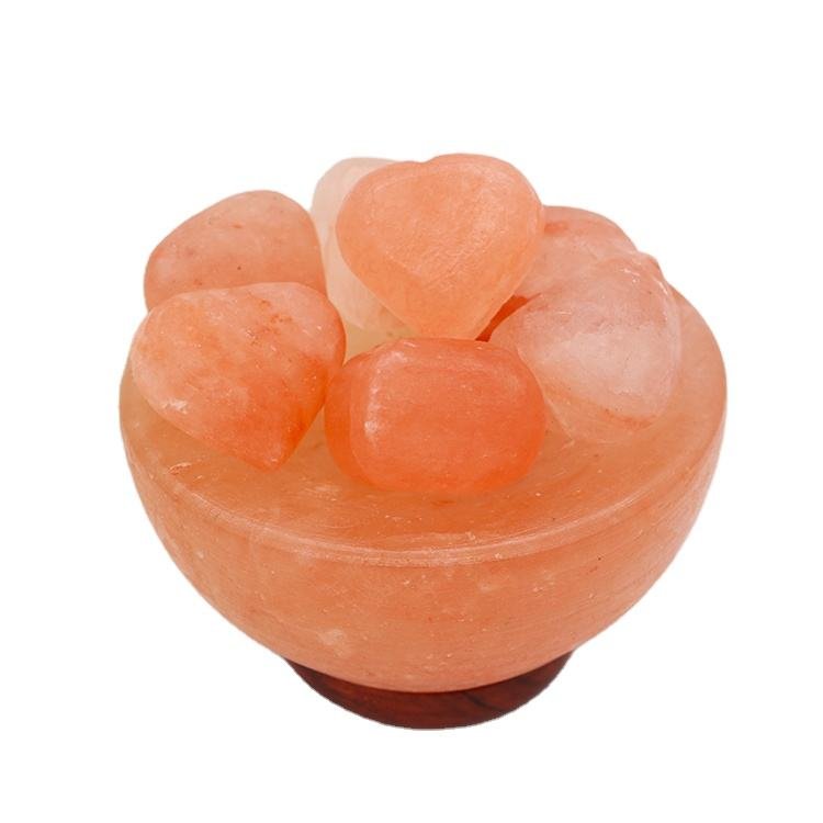 Handcrafted pink salt bowl with heart shape balls and polished dark wooden base filled with smooth pink salt heart stones