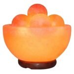Handcrafted pink salt bowl with round balls and polished wooden base filled with smooth salt massage spheres