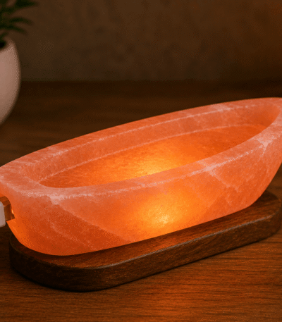 Handcrafted illuminated USB boat salt lamp carved from Himalayan pink salt mounted on a dark elongated wooden base