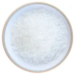 Coarse grain Himalayan white rock salt crystals neatly displayed in a round decorative ceramic plate