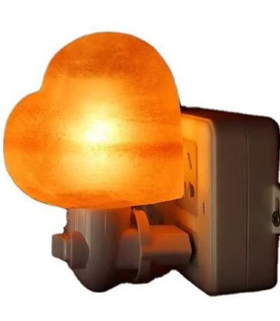 Handcrafted heart shape Himalayan pink salt wall plug-in night light plugged into an electrical outlet