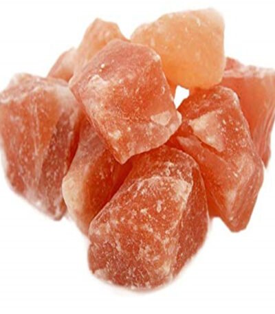 Mound of natural rough Himalayan pink rock salt chunks with crystalline facets on a pure white background