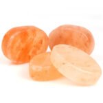 Handcrafted smooth oval and round Himalayan pink salt soap bars and massage stones displayed on a white background