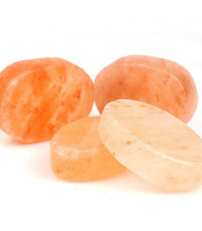 Handcrafted smooth oval and round Himalayan pink salt soap bars and massage stones displayed on a white background