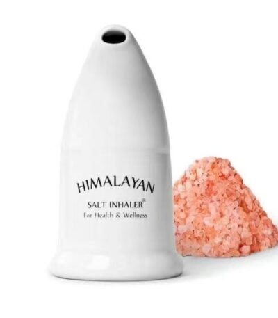 White ceramic Himalayan salt inhaler with mouthpiece standing next to a pile of coarse pink rock salt crystals